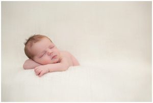 posed newborn baby sleeping on a blanket
