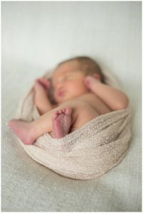 newborn baby in neutral wrap during baby photo session