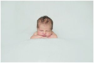 baby boy lying on his tummy during newborn photography session at home