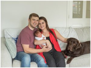 portrait of mum and dad with newborn baby in their home in Leigh